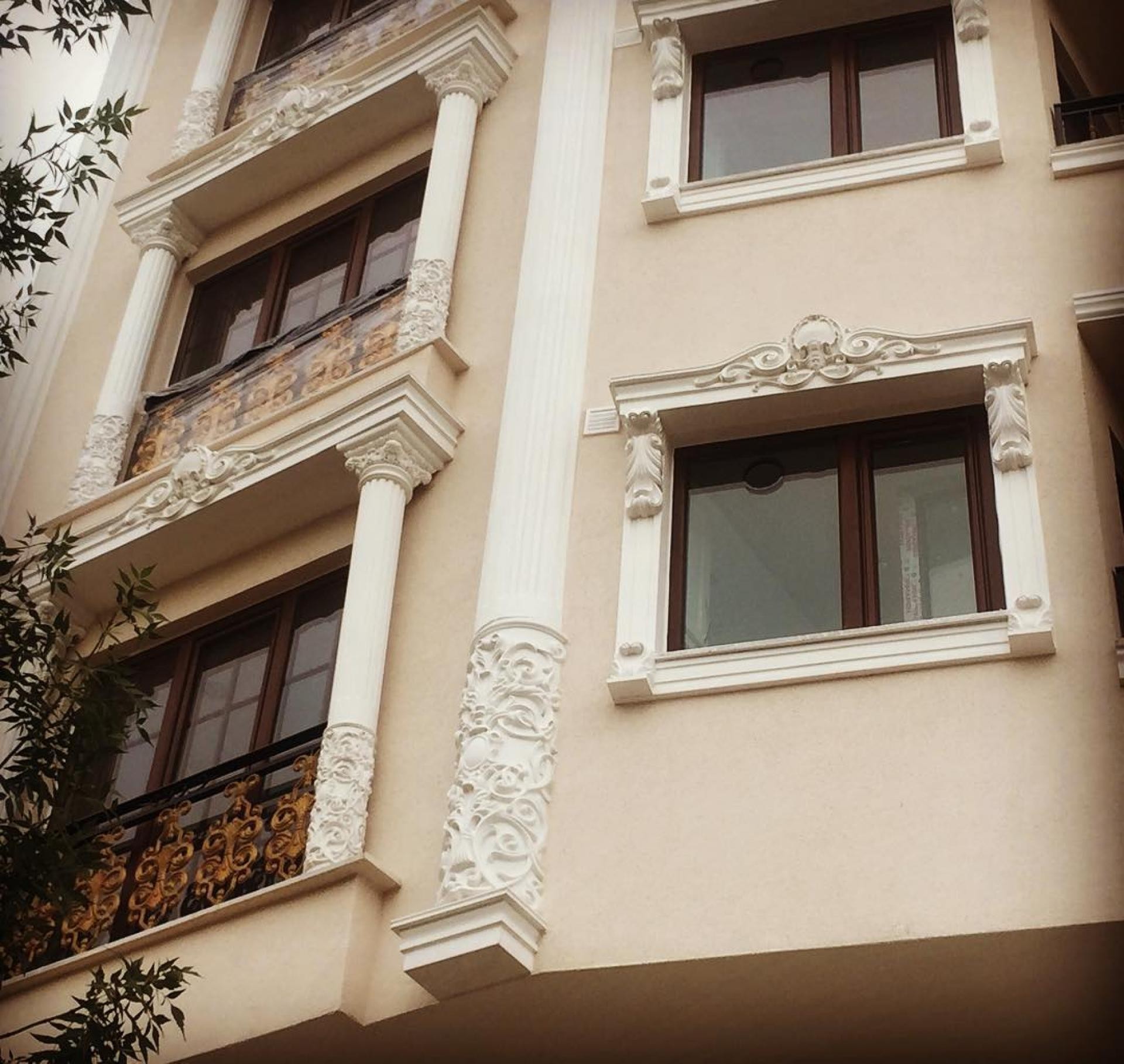Klasik otel dış cephesinde krem zemin üzerine uygulanmış beyaz poliüretan sütunlar, pencere söveleri ve dekoratif taçlar.