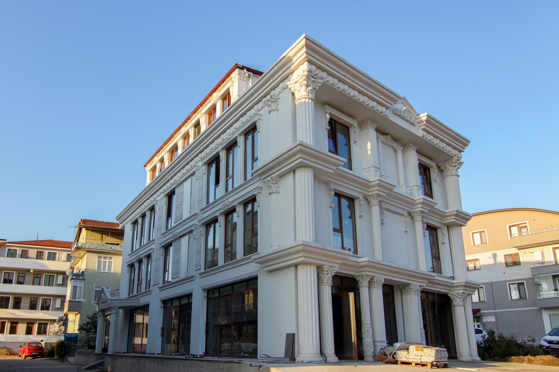 Poliüretan sütun, pilaster ve pencere söve modelleri ile süslenmiş klasik tarzda beyaz dış cephe dekorasyonu.