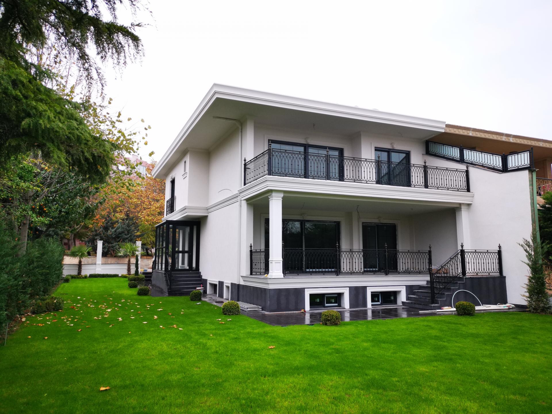 Poliüretan söve ve pilaster sütun kaplaması yapılmış iki katlı beyaz modern villa dış cephe dekorasyonu.
