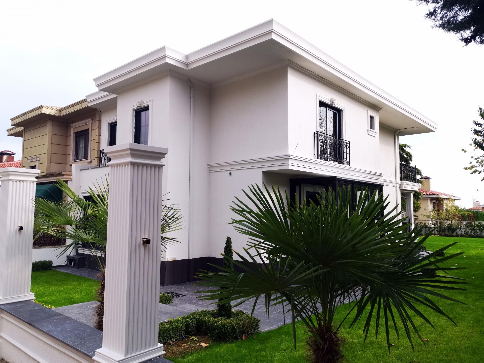Modern villa bahçesinde yivli poliüretan pilaster sütun ve beyaz dış cephe pencere söve uygulaması.