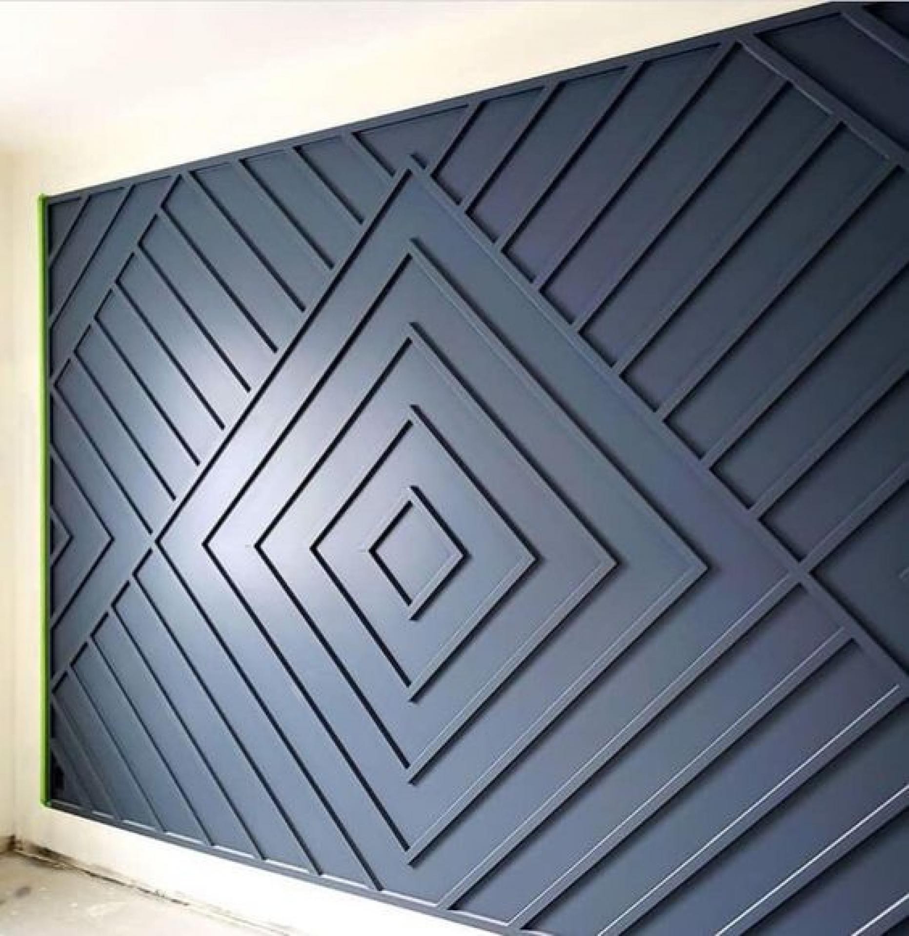 Koyu mavi boyalı poliüretan çıta modelleri ile duvara yapılmış geometrik baklava deseni uygulaması.
