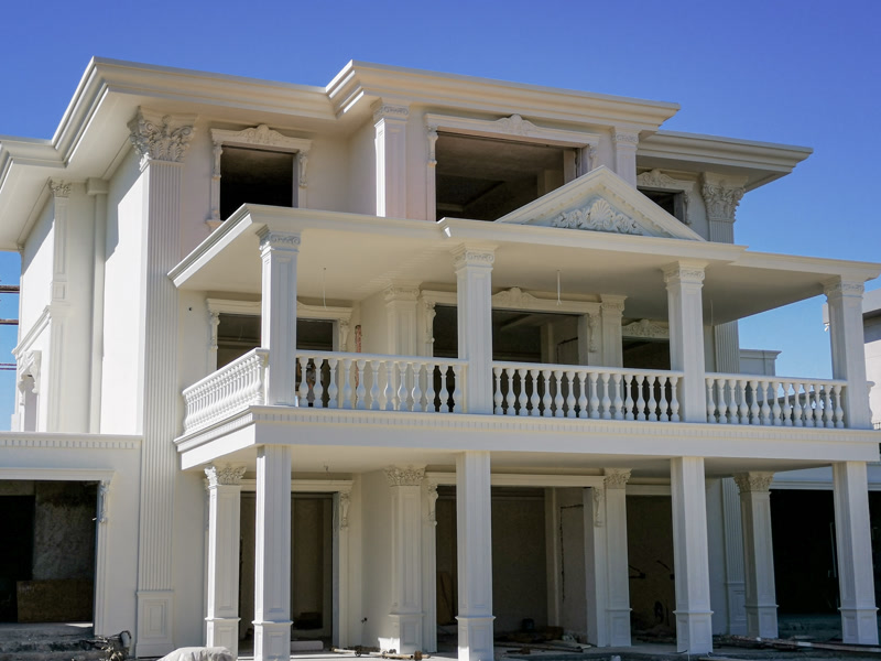 Klasik tarzda beyaz poliüretan pilaster sütunlar, dekoratif pencere söveleri ve balkon korkulukları ile süslenmiş villa dış cephesi.