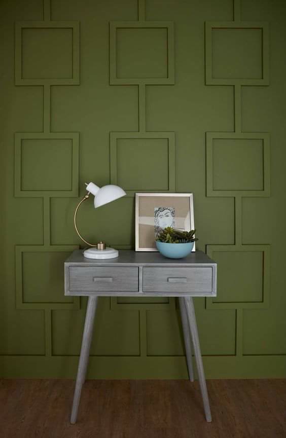 Zeytin yeşili duvarda P851350 poliüretan çıta ile yapılmış geometrik kare panel uygulaması ve önünde gri dresuar.