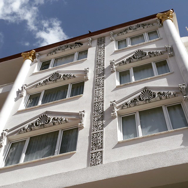 Klasik tarzda dekore edilmiş otel dış cephesinde poliüretan pencere taçları, dikey süsleme panelleri ve payandalar.