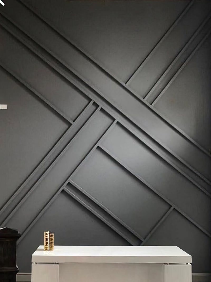 Antrasit gri duvarda P851350 poliüretan çıtalarla yapılmış modern asimetrik geometrik desen tasarımı ve önünde beyaz konsol.