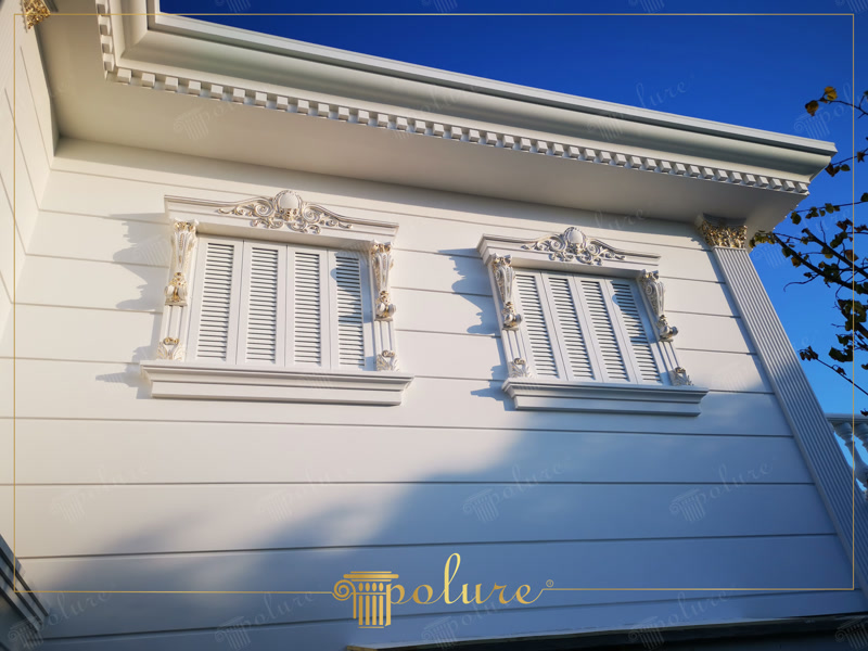Klasik villa dış cephesinde beyaz renkli poliüretan pencere sövesi, taç, payanda ve yatay panellerin görünümü.