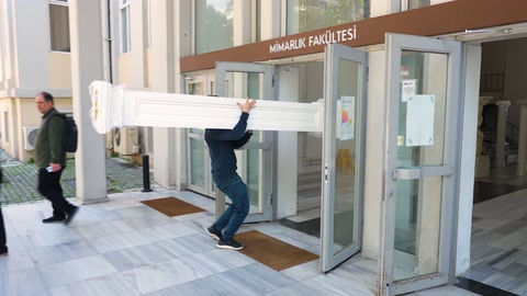 Uzun dekoratif profil etkinlik alanına iki kişi tarafından taşınıyor