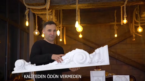 Motifli payandanın kabartma detayları ve beyaz yüzeyi yakından görülüyor