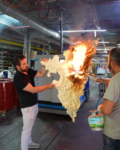 Alevli parçayı söndürme ekipmanıyla test eden iki çalışan