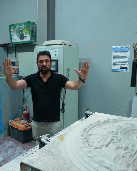 Kontrol paneli önünde elini kaldıran makine operatörü
