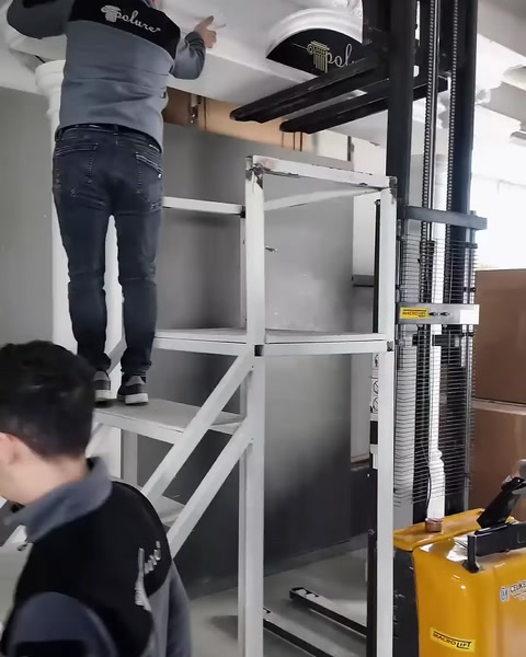 Usta, platformdan üst köşe birleşimini kontrol ederek yerleştiriyor.