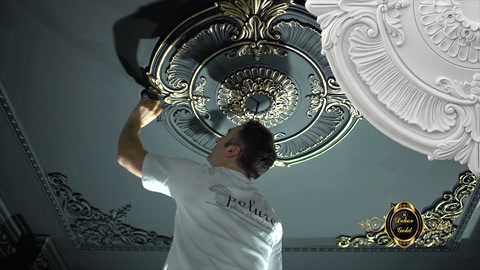 Usta, tavan göbeğinin çevresindeki dekoratif bölümü boyuyor