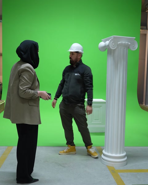Tamamlanmış sütun seti stüdyoda iki kişi tarafından inceleniyor