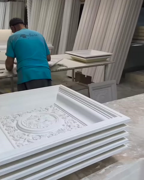 Beyaz kare kubbe panelleri atölye tezgâhında üst üste duruyor