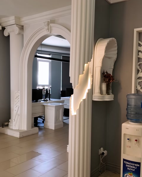 Kemerli kapı sövesi ve sütunlarla showroom girişi görünüyor