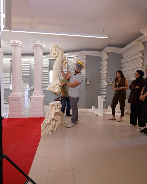Çalışan büyük gelinlik formlu rölyefi kırmızı halıya taşıyor