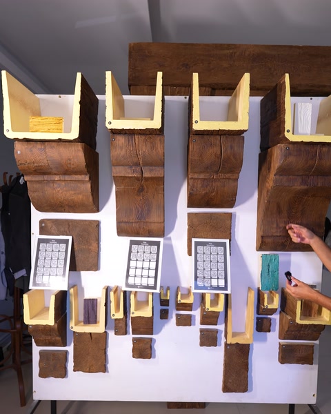 Duvar panosundaki ahşap görünümlü numuneleri gösteren showroom çalışanı