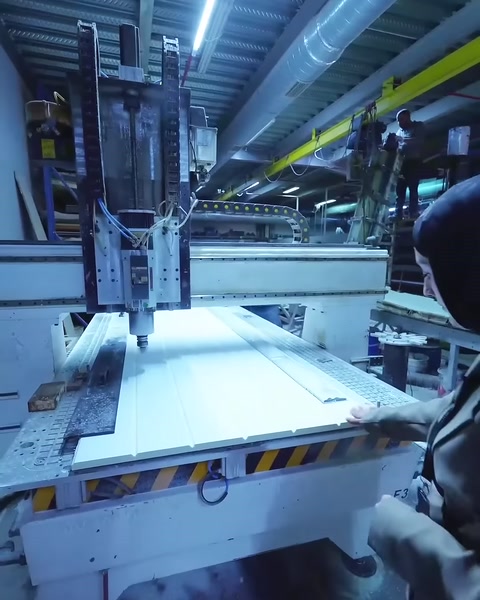 Üretim görevlisi CNC ile işlenen paneli yakından takip ediyor