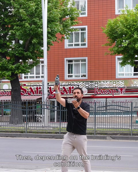 Teknisyen sokakta bina cephesini tarayıcı cihazla ölçüyor